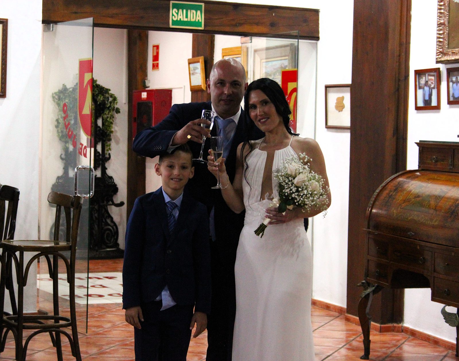 Os noivos e o filho brindam à entrada