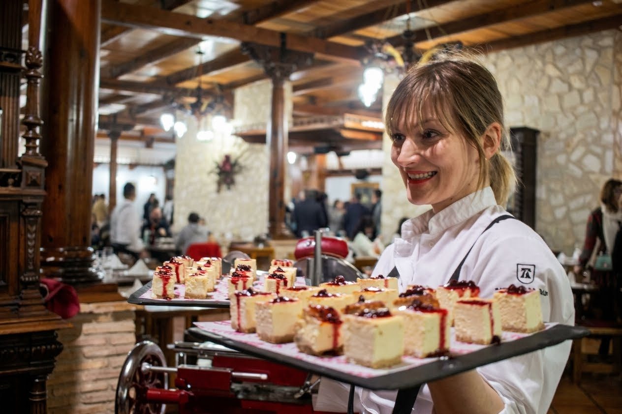 Camarera con una bandeja de pasteles de queso en el salón