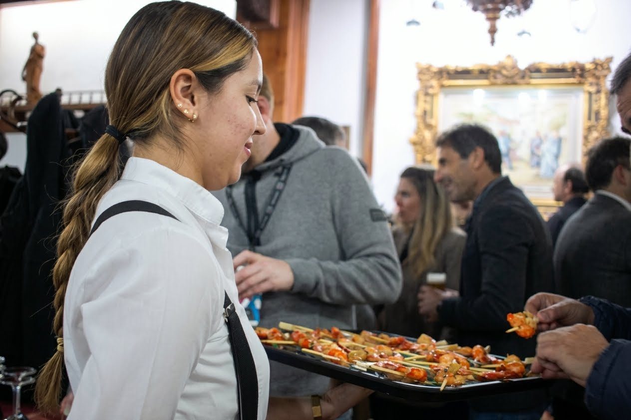 Camarera con una bandeja de tapas entre los invitados
